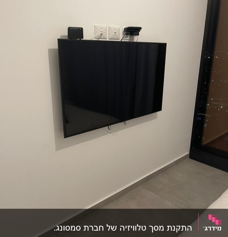 טלוויזיה תלויה על הקיר עם כבלים מחוברים